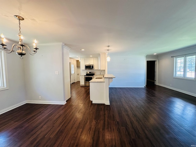 kitchen featuring stainless steel appliances, an inviting chandelier, open floor plan, white cabinets, and baseboards