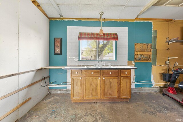 kitchen featuring brown cabinetry and a sink