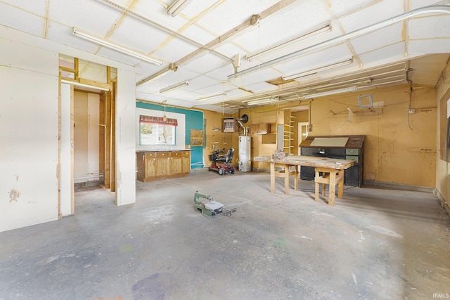 miscellaneous room featuring a sink, concrete flooring, and gas water heater
