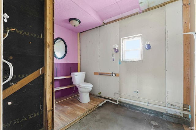 bathroom featuring toilet and concrete flooring
