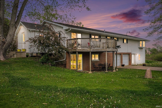 back of house with a yard, a wooden deck, aphalt driveway, and an attached garage