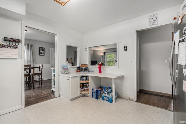 kitchen with light floors, light countertops, baseboards, and white cabinets