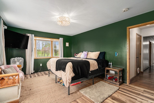 bedroom with baseboards and wood finished floors