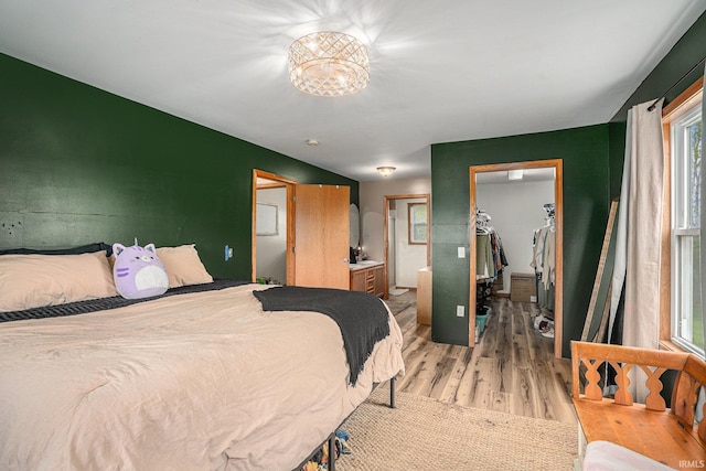 bedroom featuring light wood-style flooring, a spacious closet, and a closet