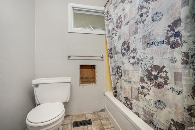 bathroom featuring toilet, visible vents, stone finish flooring, and shower / bathtub combination with curtain