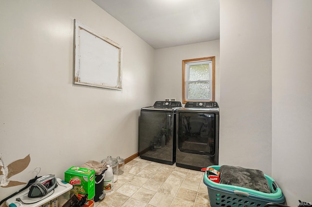 laundry area with washing machine and clothes dryer, baseboards, and laundry area