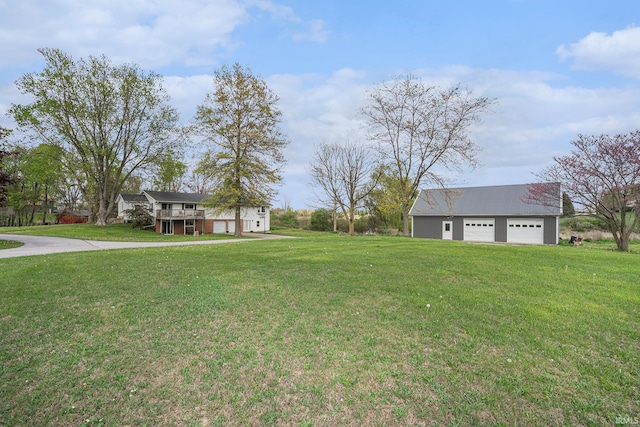 view of yard featuring driveway and a garage