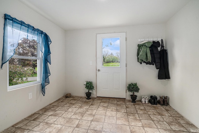 doorway to outside featuring stone finish flooring and plenty of natural light