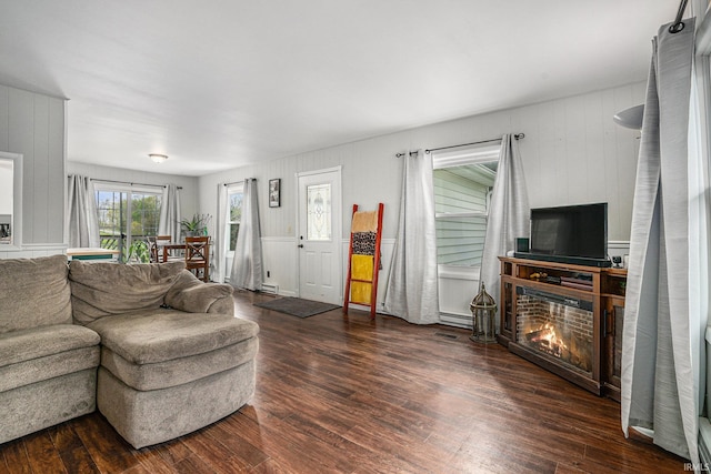 living room featuring a glass covered fireplace and wood finished floors