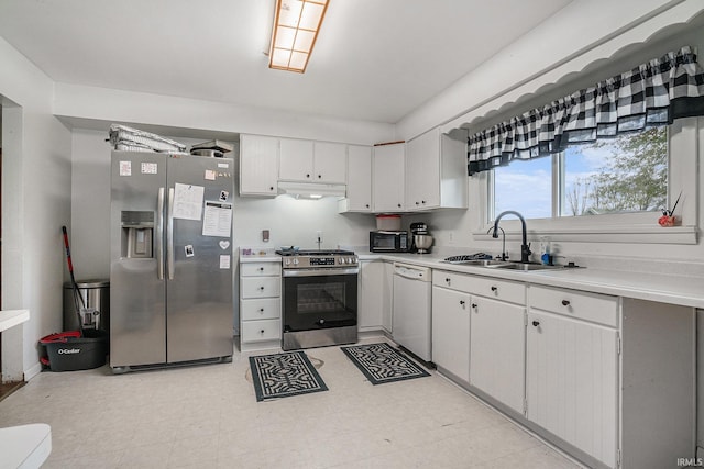 kitchen featuring a sink, under cabinet range hood, light countertops, and appliances with stainless steel finishes