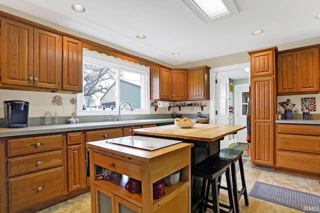 3806 S State Road 3, New Castle, IN 47362 - kitchen with a breakfast bar, a sink, a kitchen island, and brown cabinets