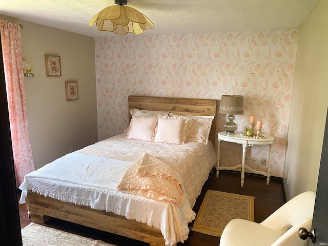 bedroom featuring wallpapered walls and a textured ceiling