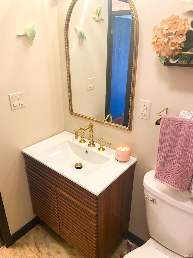 half bathroom with toilet and vanity