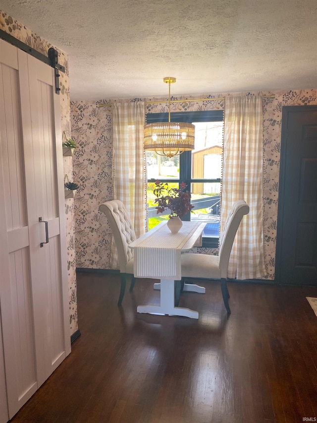 dining space with wood finished floors, a textured ceiling, an inviting chandelier, baseboards, and wallpapered walls