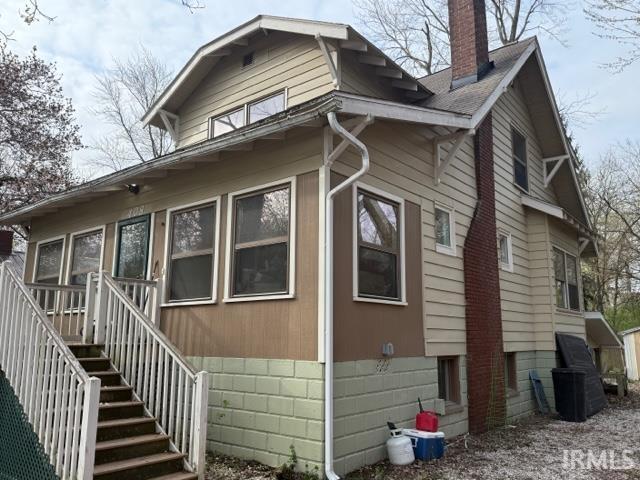408 N 8th St, Petersburg, IN 47567 - view of side of home featuring a chimney and stairway
