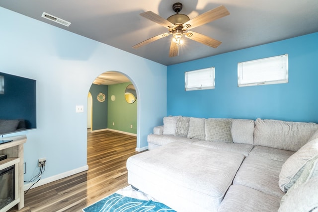 11910 E 690 S, Hudson, IN 46747 - living room featuring wood finished floors, visible vents, arched walkways, a ceiling fan, and baseboards