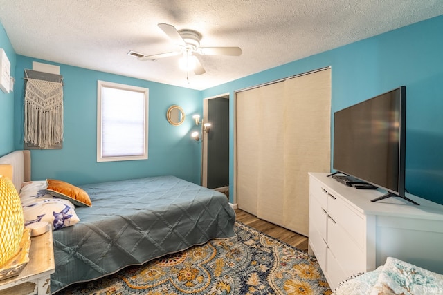 11910 E 690 S, Hudson, IN 46747 - bedroom featuring a closet, a textured ceiling, wood finished floors, and a ceiling fan