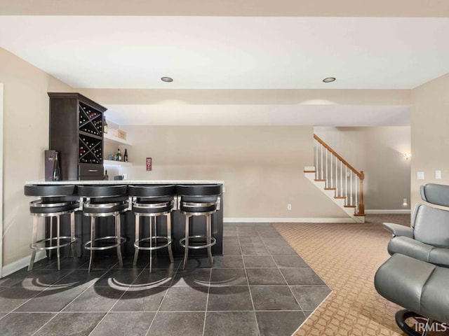 1817 Prestwick Ln, Fort Wayne, IN 46814 - bar featuring baseboards, stairs, a bar, and dark tile patterned floors