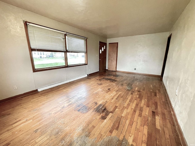 unfurnished room with baseboards and hardwood / wood-style floors