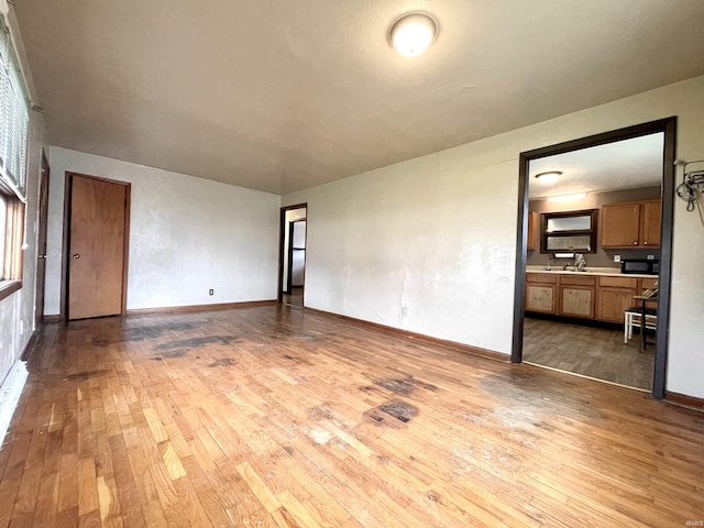 unfurnished living room featuring baseboards and hardwood / wood-style floors