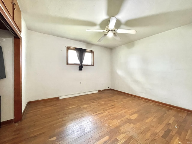 spare room with ceiling fan, baseboards, a baseboard radiator, and hardwood / wood-style floors