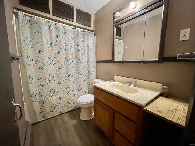 bathroom featuring toilet, curtained shower, vanity, and wood finished floors