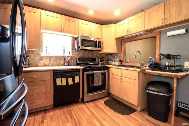 12190 W County Line Rd, Plymouth, IN 46563 - kitchen with light wood-style floors, tasteful backsplash, appliances with stainless steel finishes, and a sink