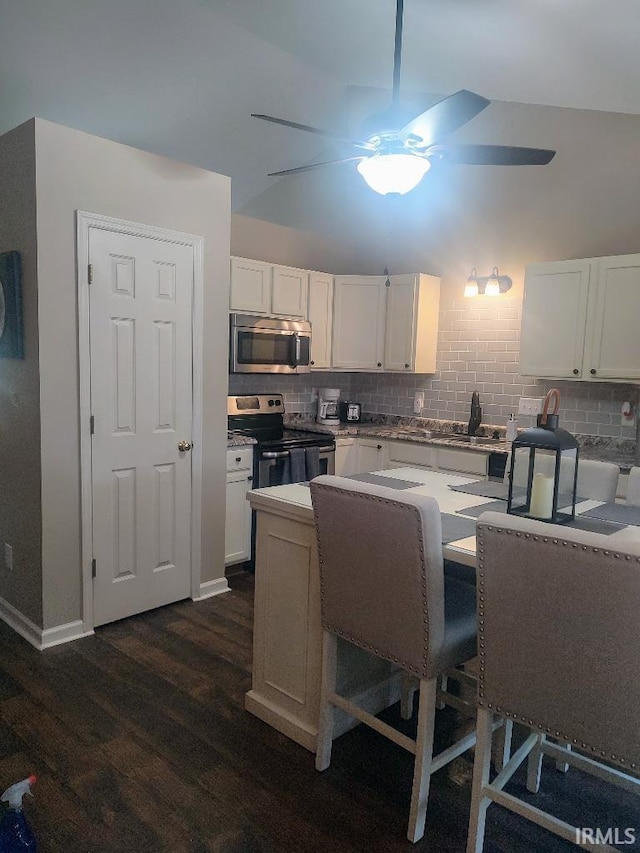 337 W White Pine Ct, Bloomington, IN 47403 - kitchen featuring white cabinets, appliances with stainless steel finishes, dark wood-style floors, and tasteful backsplash