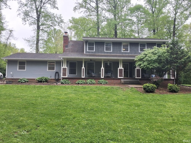 traditional-style home featuring a chimney, a porch, and a front lawn