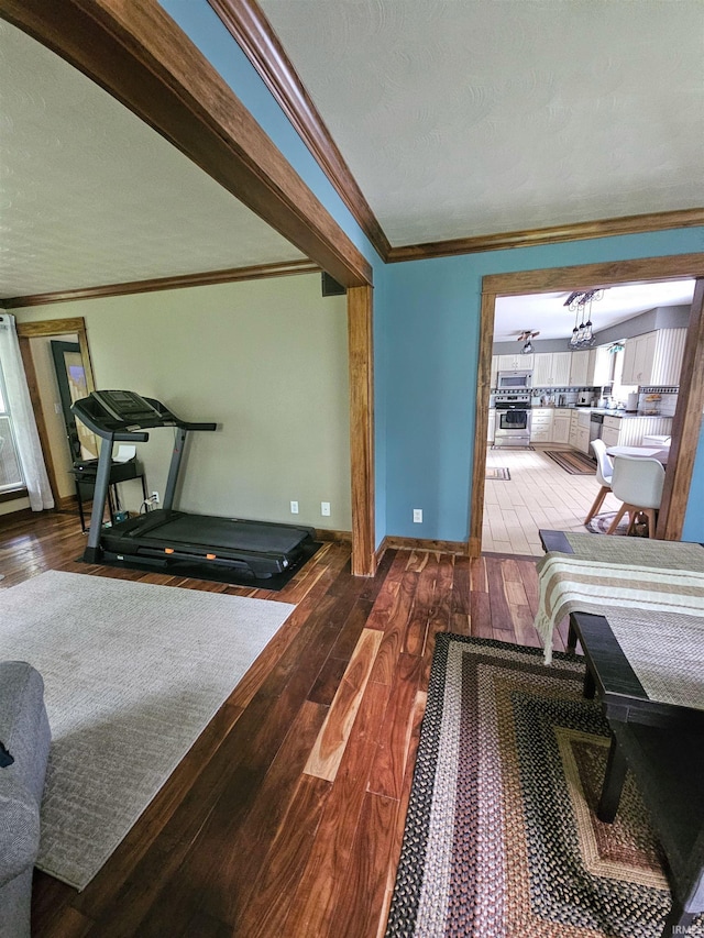 interior space featuring baseboards, ornamental molding, and hardwood / wood-style flooring