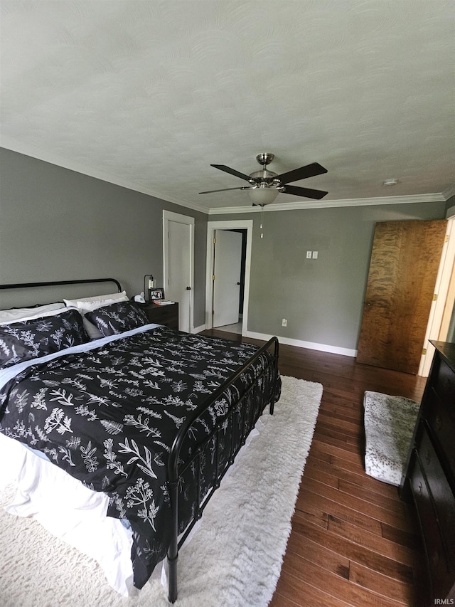 bedroom featuring baseboards, hardwood / wood-style floors, crown molding, and a ceiling fan