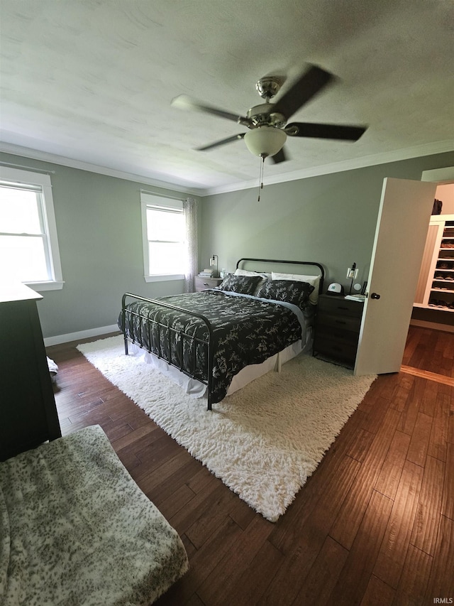 bedroom with ceiling fan, baseboards, ornamental molding, and hardwood / wood-style flooring