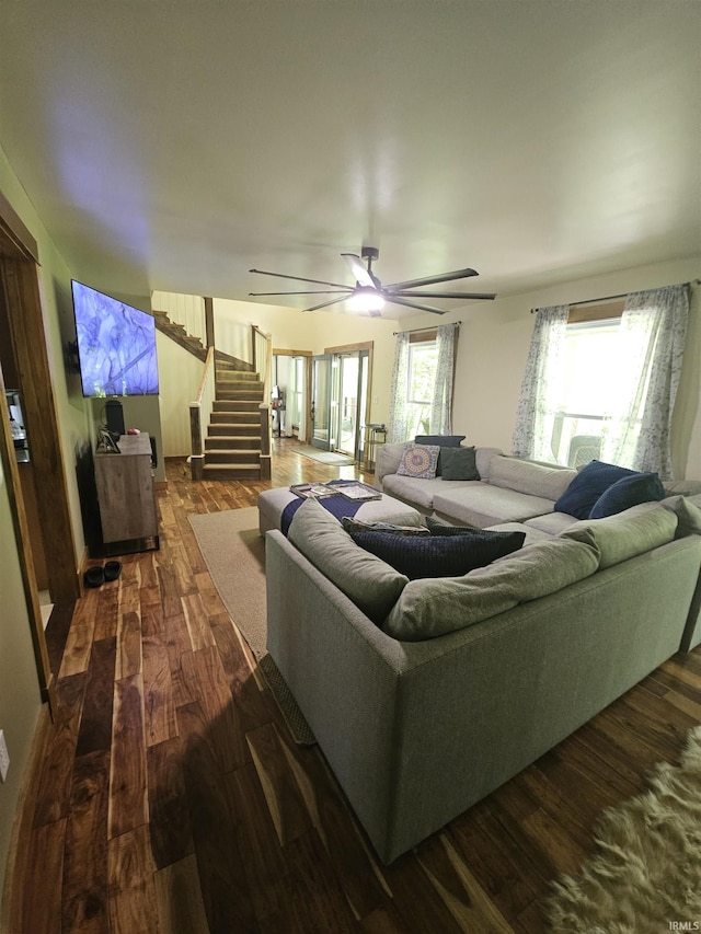 living room with stairway, ceiling fan, and dark wood-style floors