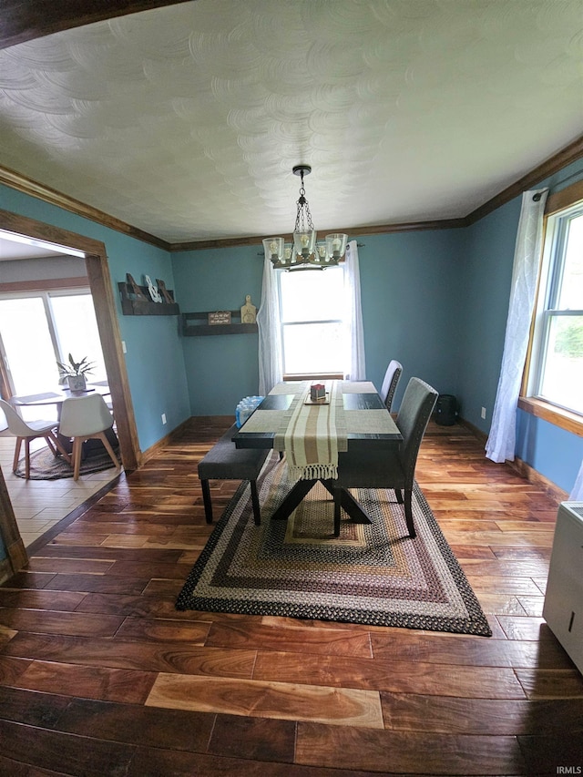 dining space with an inviting chandelier, hardwood / wood-style flooring, baseboards, and ornamental molding