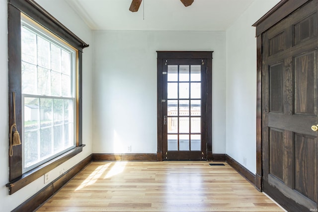 unfurnished room with baseboards, light wood-style flooring, and a ceiling fan