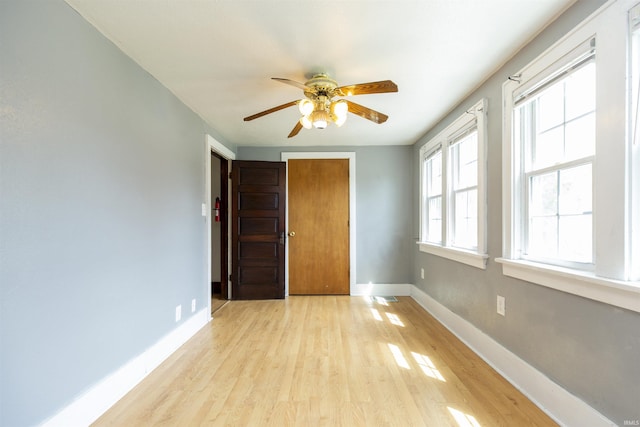 unfurnished bedroom featuring a closet, baseboards, ceiling fan, visible vents, and light wood-style floors