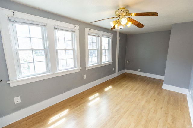 empty room featuring baseboards, light wood-style flooring, and ceiling fan