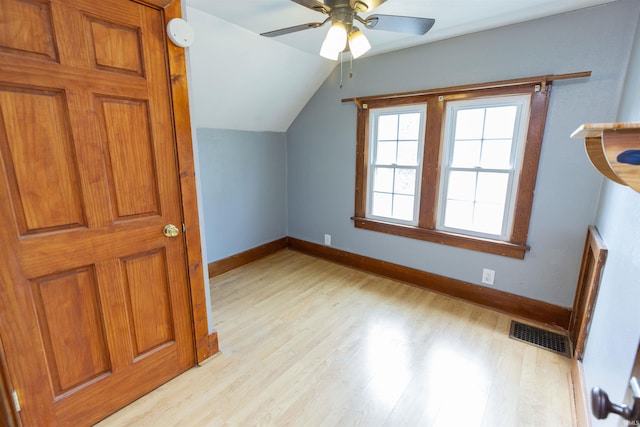 additional living space with light wood finished floors, visible vents, baseboards, ceiling fan, and lofted ceiling