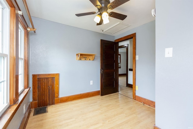 empty room featuring baseboards, visible vents, ceiling fan, and wood finished floors