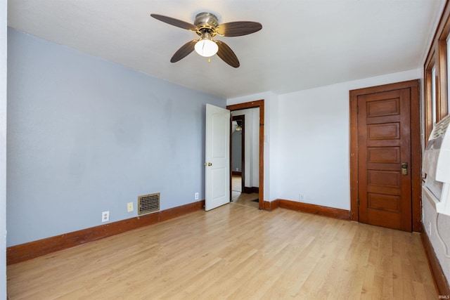 empty room featuring light wood-type flooring, visible vents, baseboards, and a ceiling fan