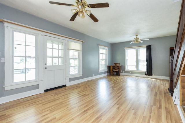 interior space with light wood-style flooring, baseboards, a ceiling fan, and visible vents