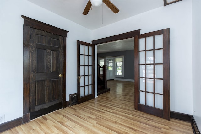 foyer entrance with baseboards, stairs, light wood-style flooring, and a ceiling fan