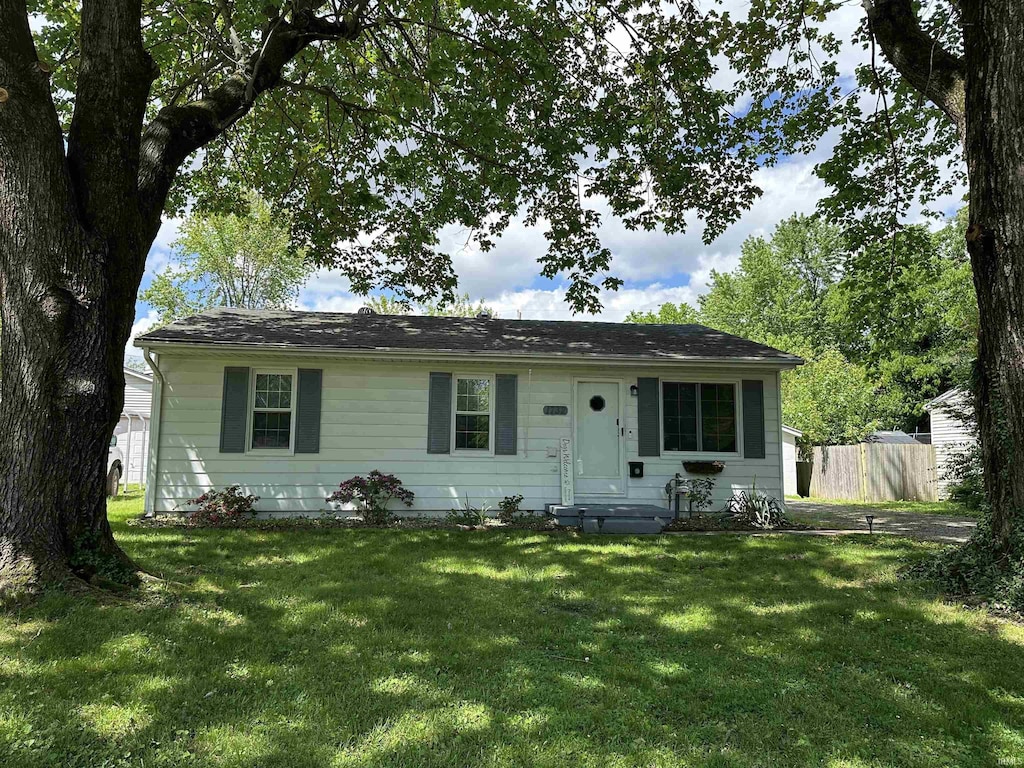 view of front facade featuring fence and a front yard