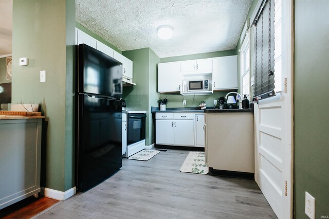 1732 Marbo Ave, Evansville, IN 47714 - kitchen with freestanding refrigerator, white microwave, electric range, white cabinetry, and a textured ceiling