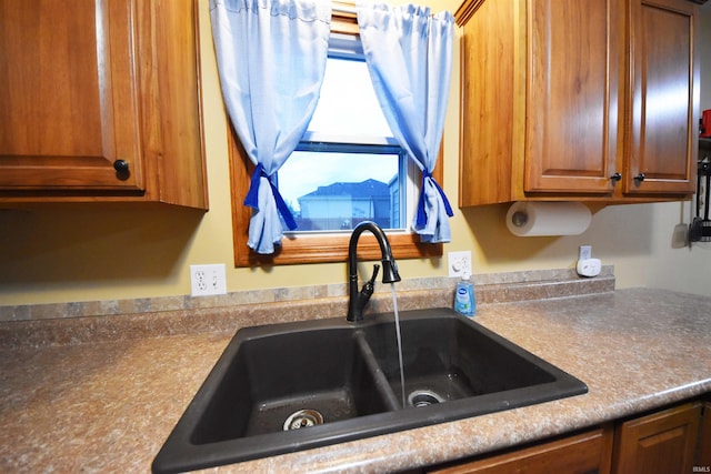 interior details with brown cabinetry and a sink