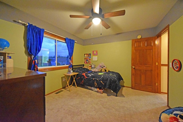 carpeted bedroom with a ceiling fan and visible vents