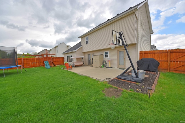 rear view of house with a patio area, a trampoline, a fenced backyard, a lawn, and a playground