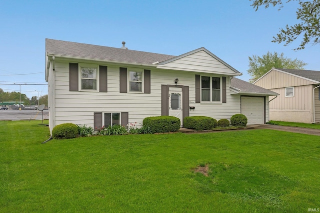 split foyer home featuring driveway, a front yard, a shingled roof, and a garage