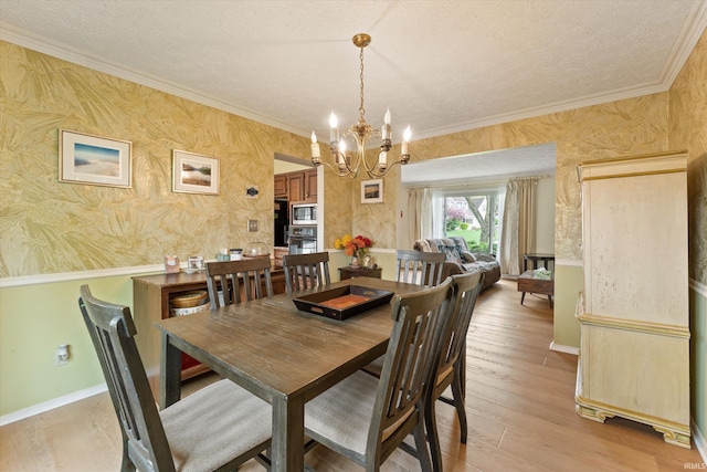 dining space with a chandelier, crown molding, wallpapered walls, a textured ceiling, and baseboards
