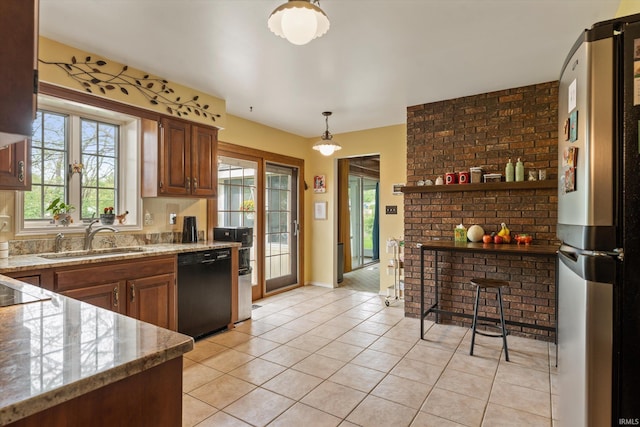 kitchen with freestanding refrigerator, a sink, dishwasher, and plenty of natural light